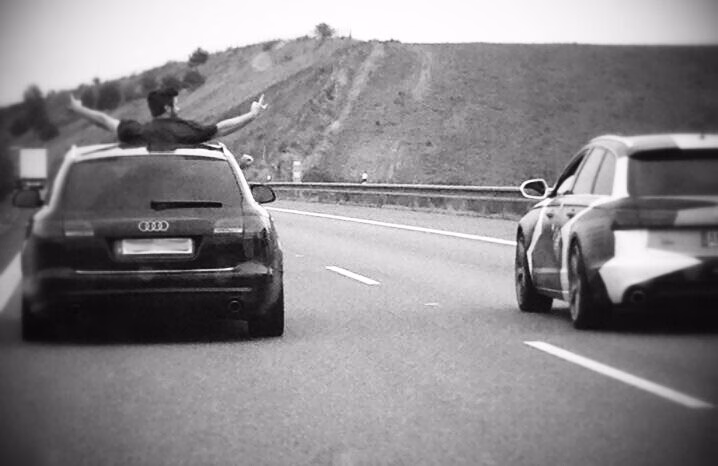Wochenende in Prag Schwarzer Audi auf der Autobahn, aus dem Schiebedach streckt jemand die Arme aus